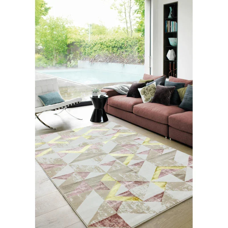 Geometric patterned area rug in modern living room with pink sofa and large window view