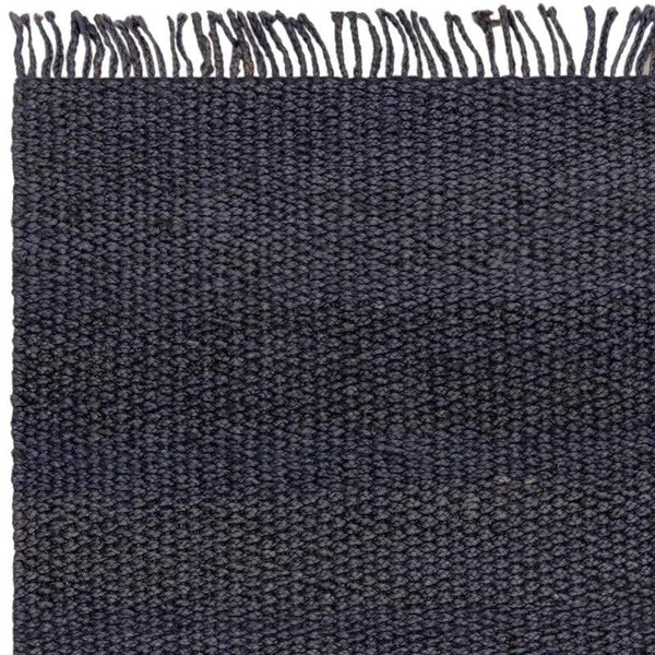 Dark woven wool rug with fringe edge and textured surface detail