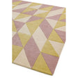 Pastel geometric area rug with pink, yellow, and cream triangle pattern