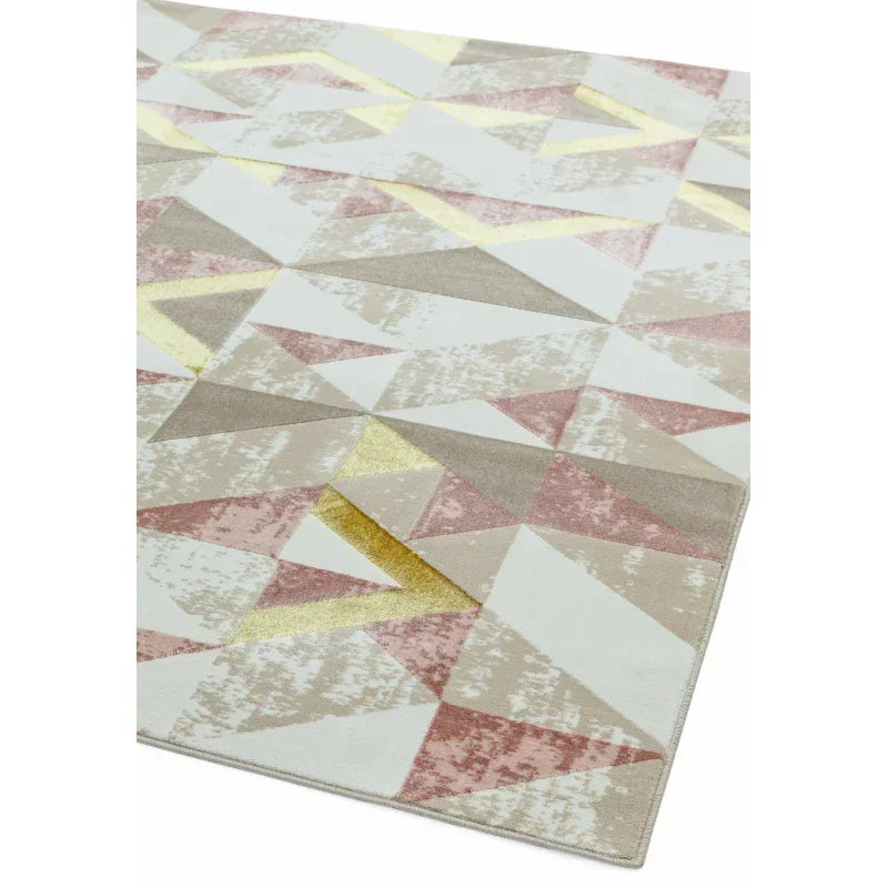 Geometric area rug with blush, beige, white, and gold triangle pattern