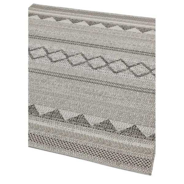 Grey patterned area rug with geometric design and textured fabric close up