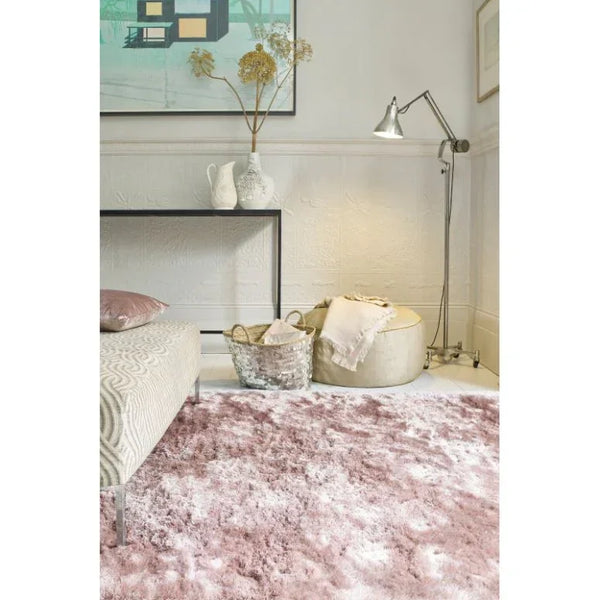 Blush pink shaggy area rug in modern living room with ottoman and metal floor lamp
