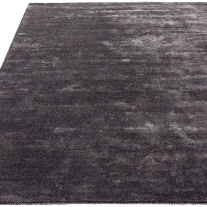 Charcoal grey velvet rug with soft texture and subtle sheen, shown from angled view