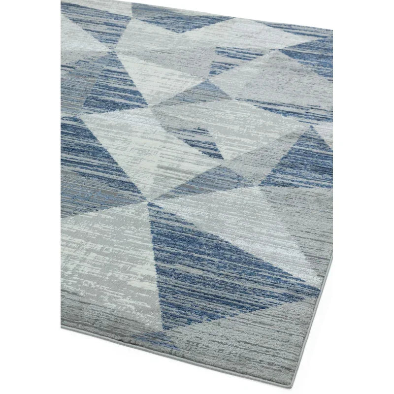 Modern area rug with blue and grey geometric patterns and textured surface