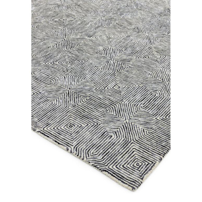Grey geometric patterned rug with textured square spiral design, corner view