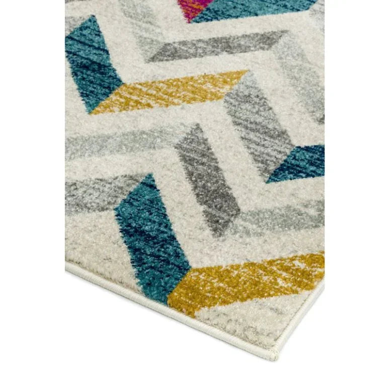 Geometric patterned rug corner with teal, grey, gold, and cream colors
