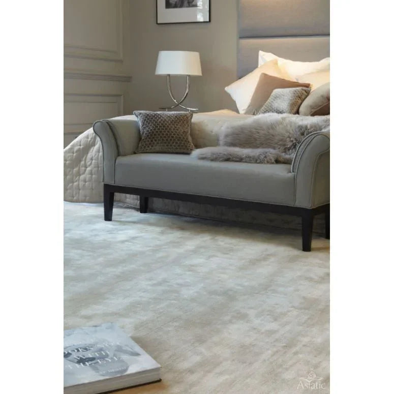 Neutral wool rug in modern bedroom setting with sofa and cushions