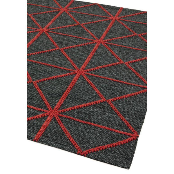 Dark grey area rug with red geometric pattern and textured surface