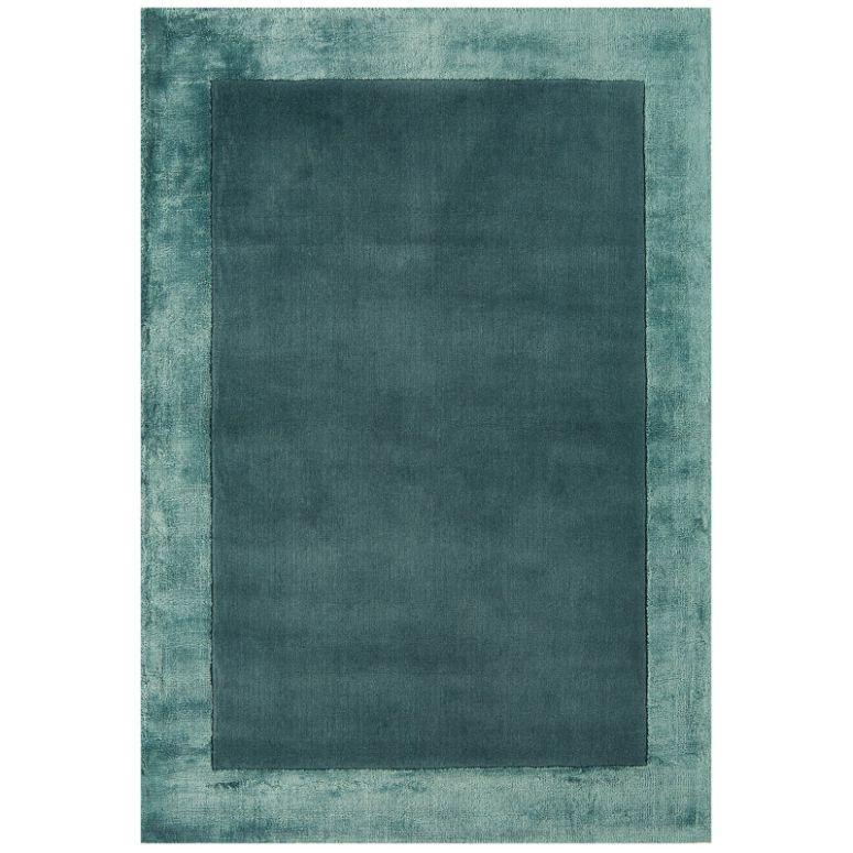 Teal blue area rug with soft textured border and solid center, shown from above