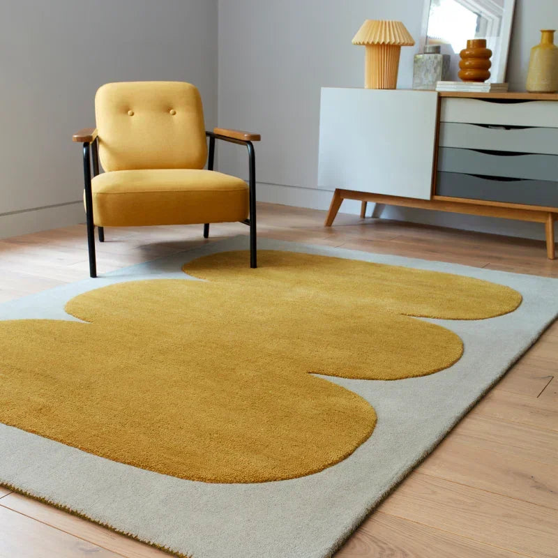 Modern armchair with yellow upholstery and geometric rug in contemporary living room