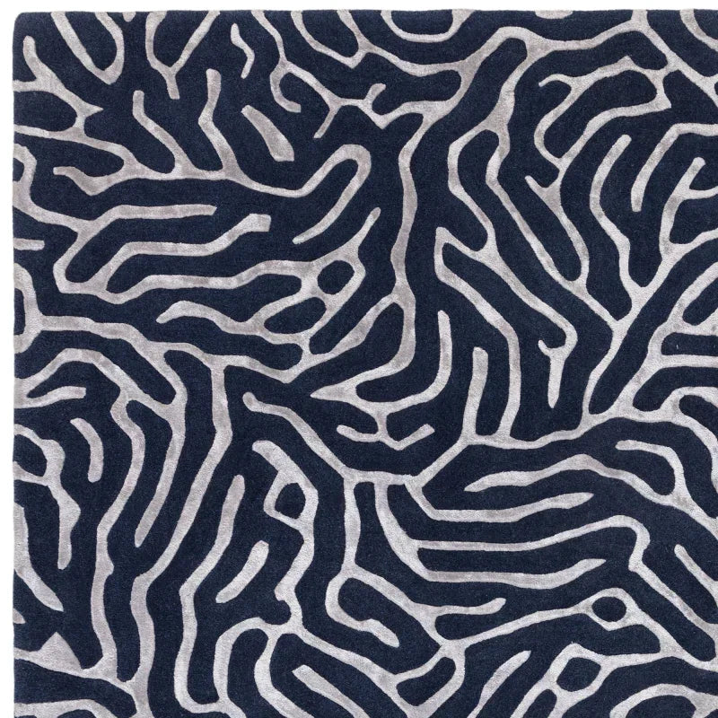 Navy and silver patterned rug with abstract raised design, close-up of textured fabric