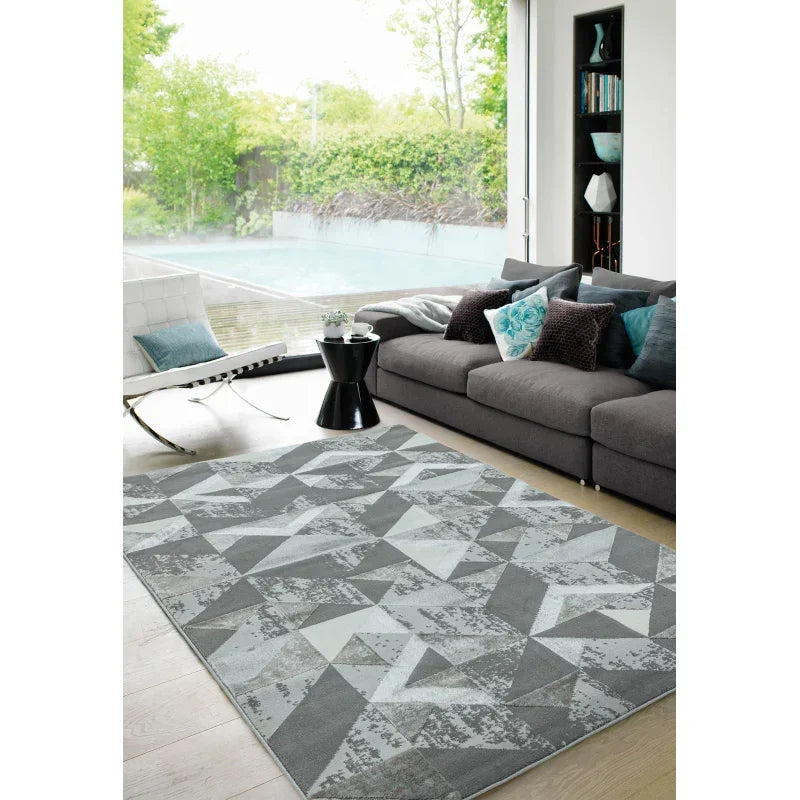 Geometric grey area rug in modern living room with grey sofa and accent pillows