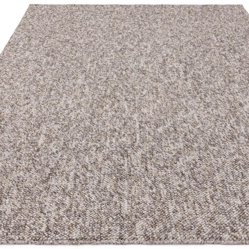 Textured beige wool rug with looped pile and neutral tones, angled top-down view