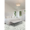 Modern bedroom with tufted bed, cream bench, and wavy patterned rug