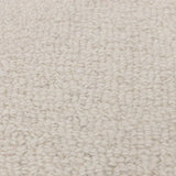 Closeup of cream textured carpet fabric with looped wool surface