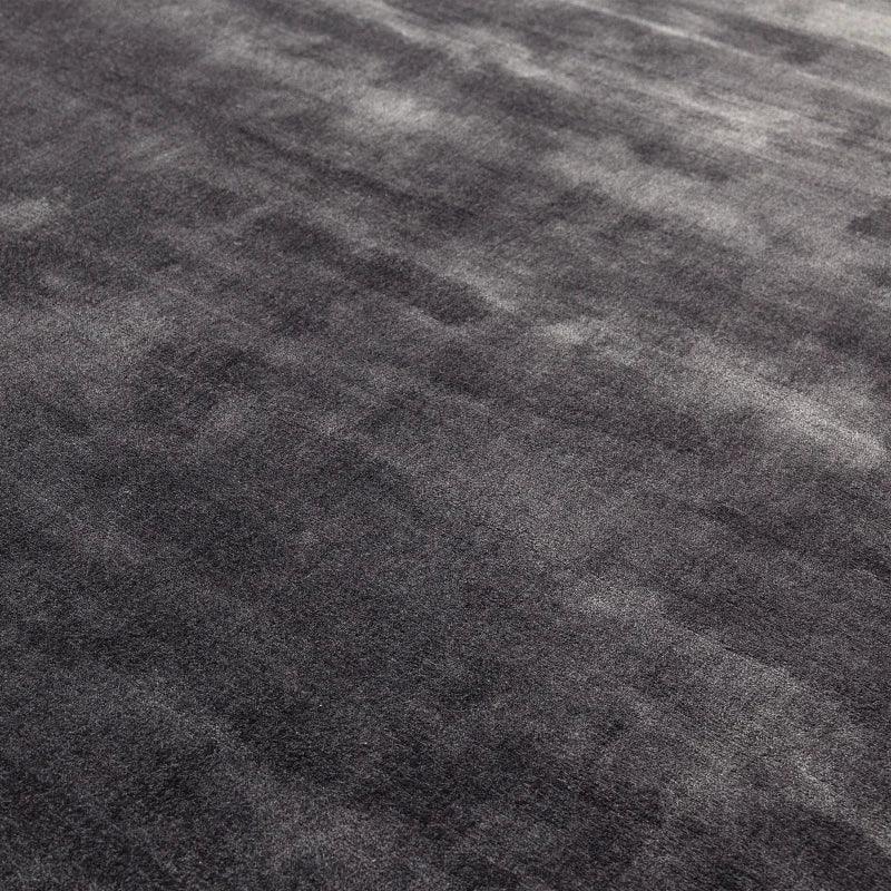 Close view of dark grey area rug with soft, velvety texture and subtle patterned shading