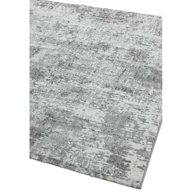 Grey distressed area rug with textured abstract pattern and low-pile finish