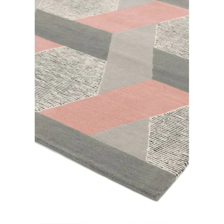 Geometric area rug with pink, grey, and cream pattern, close-up of corner detail