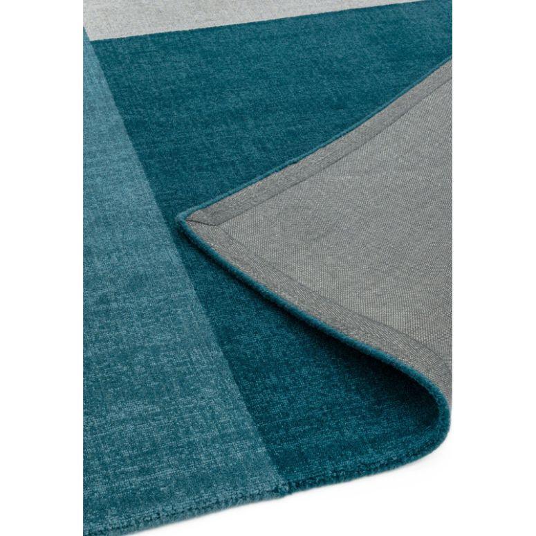 Blue and grey area rug corner folded to show backing detail