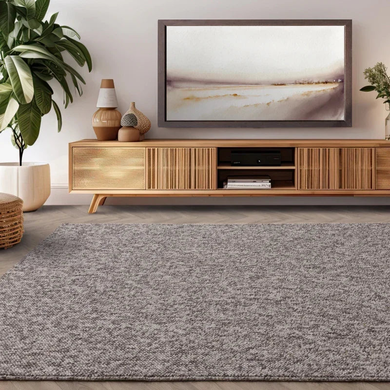 Grey textured rug in modern living room with wooden TV unit and decorative vases