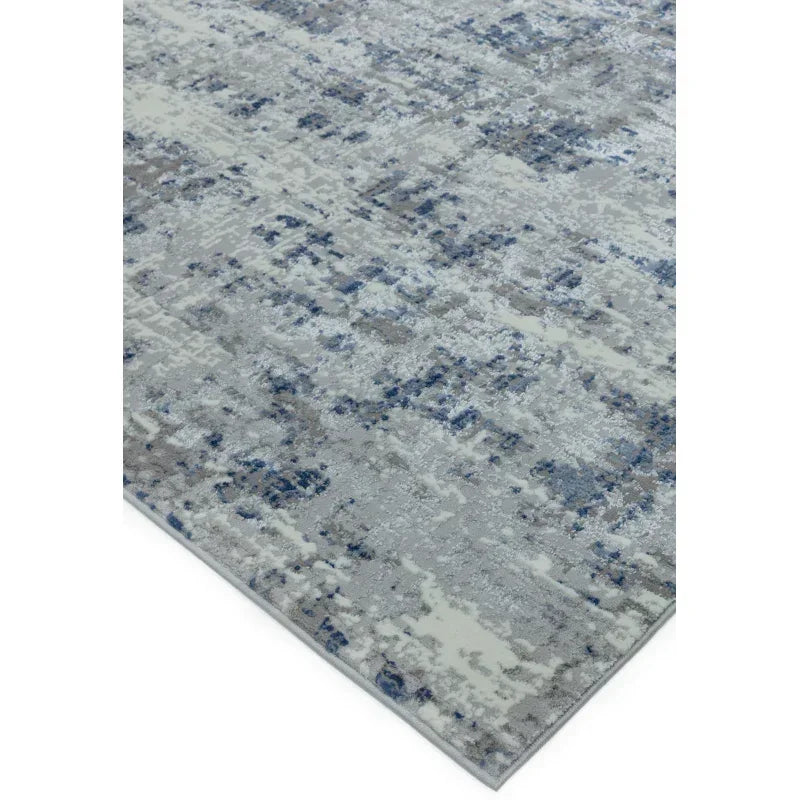 Modern area rug with blue, grey, and cream abstract pattern, corner view