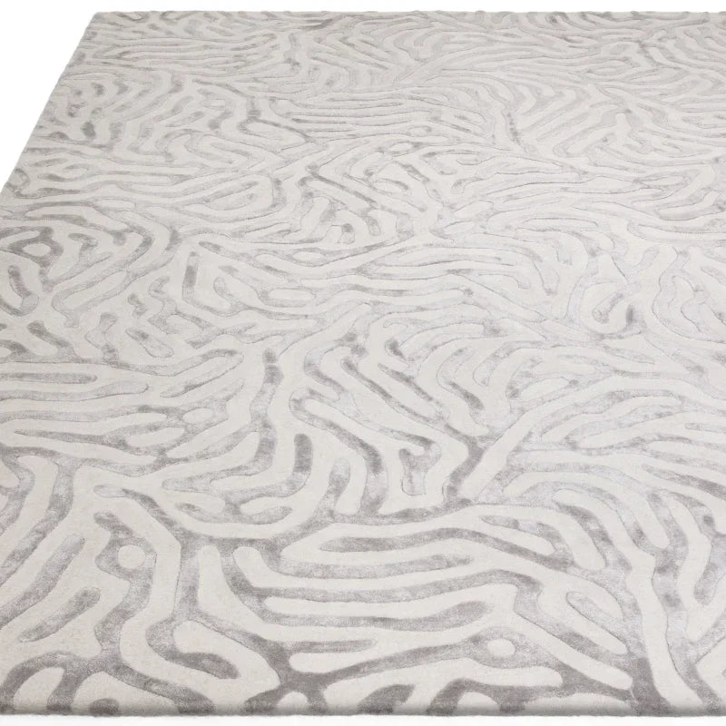 Modern area rug with raised abstract pattern in light grey and off-white tones