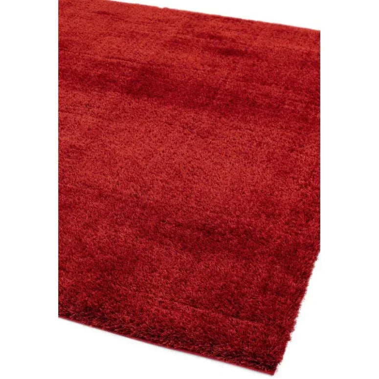 Red shaggy rug close-up showing soft pile texture and rectangular corner angle