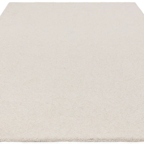 Rectangular cream wool rug with short pile texture viewed from low angle