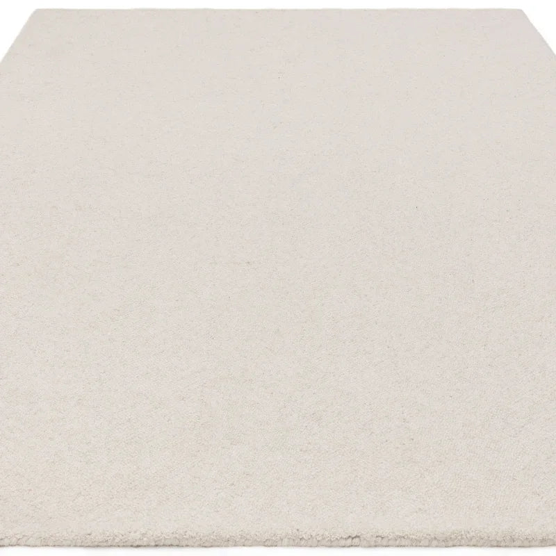 Rectangular cream wool rug with short pile texture viewed from low angle