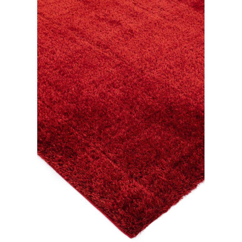 Red shaggy rug close-up showing soft textured pile and finished edge