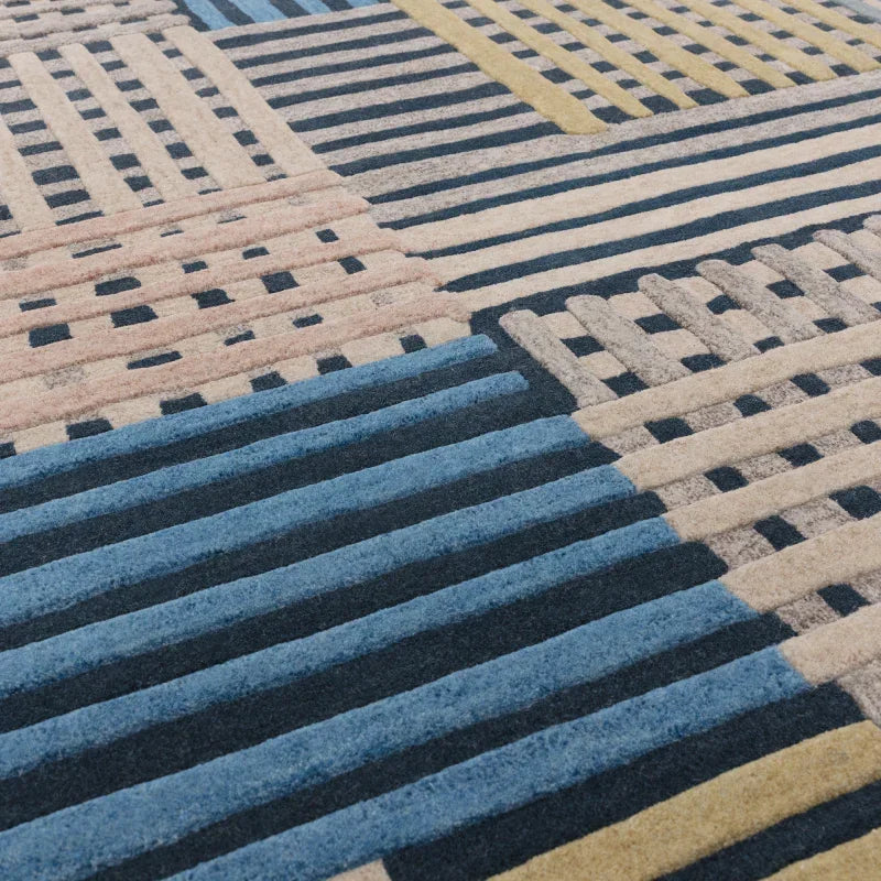 Modern geometric rug with blue, beige, and yellow striped and checked pattern