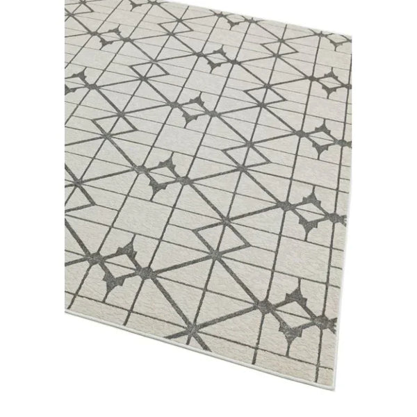 Beige area rug with geometric grey line pattern and star shapes, corner angle view