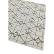 Beige area rug with geometric grey line pattern and star shapes, corner angle view