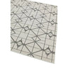 Beige area rug with geometric grey line pattern and star shapes, corner angle view