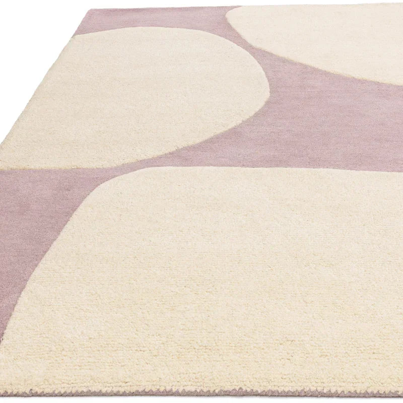 Modern area rug with cream geometric shapes on a light mauve background