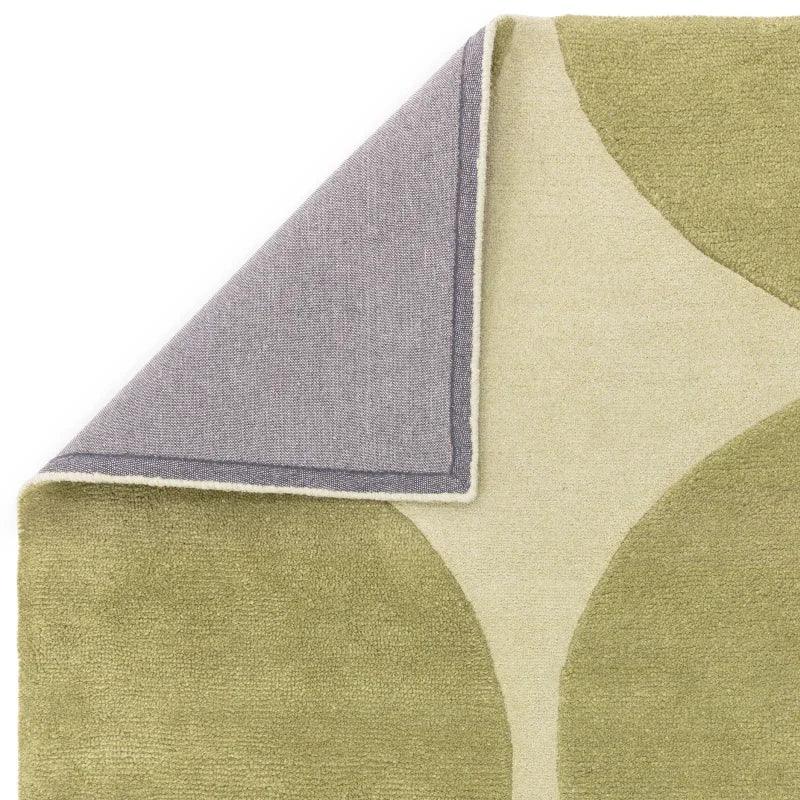 Green and beige modern abstract pattern rug corner flipped to show backing