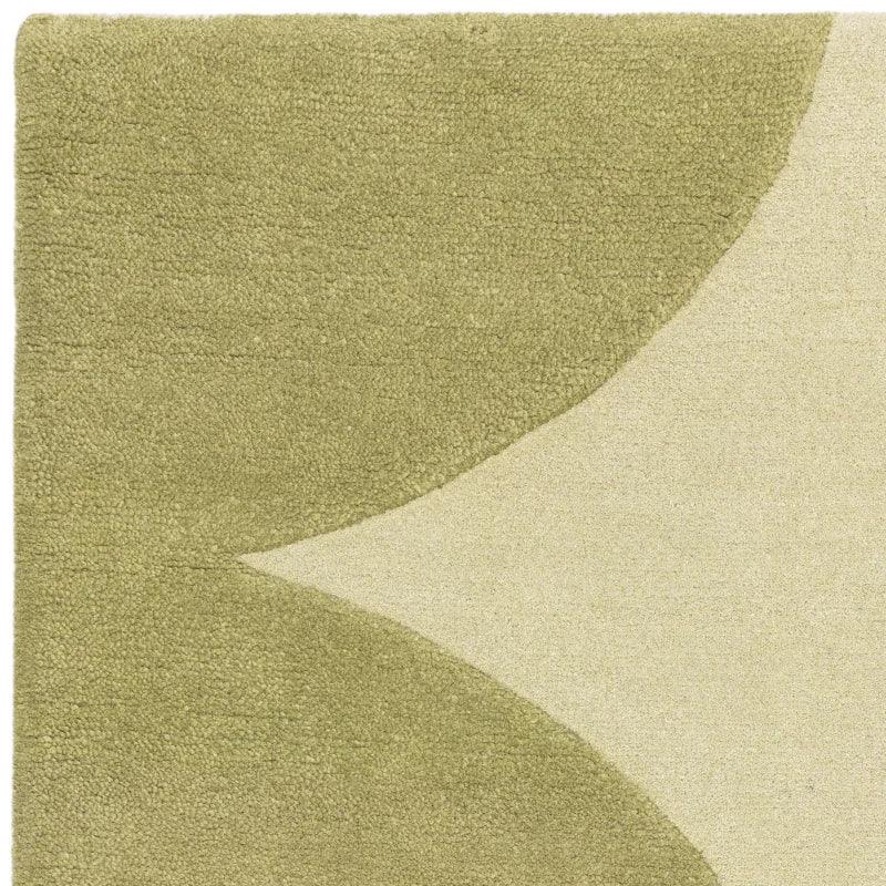 Close-up of green and beige abstract wool rug with geometric pattern