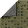 Green polka dot rug with textured pattern and visible corner showing backing