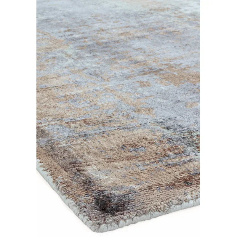 Closeup of modern area rug with textured beige and grey pattern