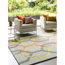 Geometric patterned rug in beige, yellow, and grey with armchairs and decorative cushions