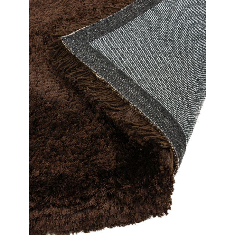 Brown shaggy rug with soft pile and corner showing woven backing