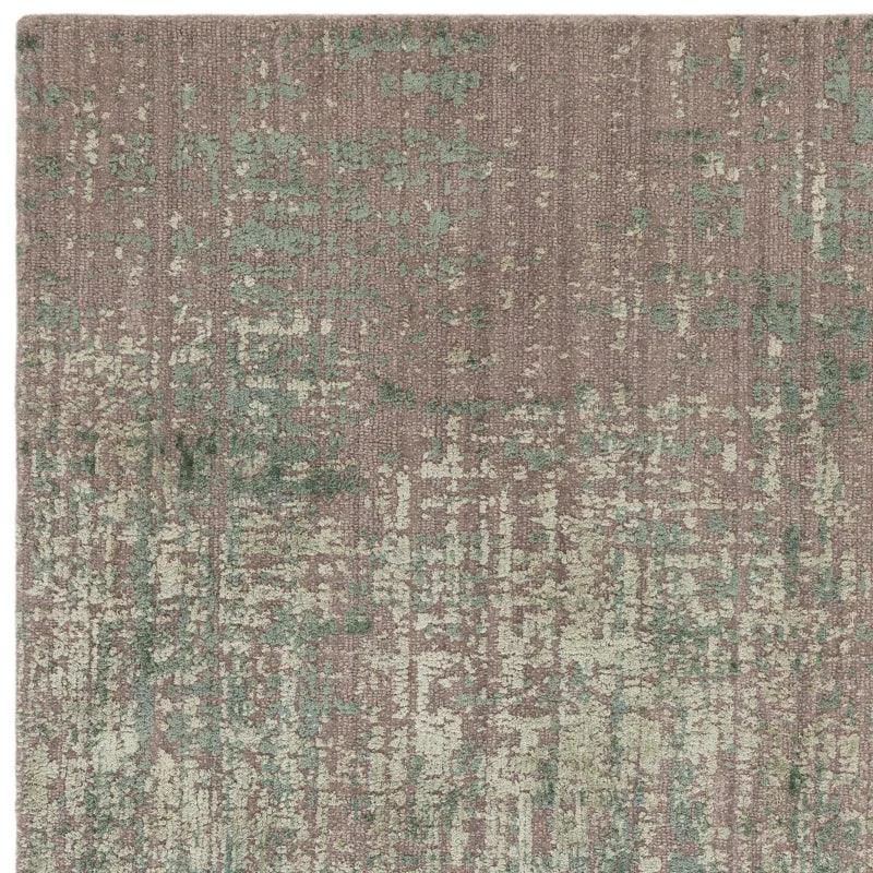 Textured area rug with green and beige abstract pattern and soft woven surface