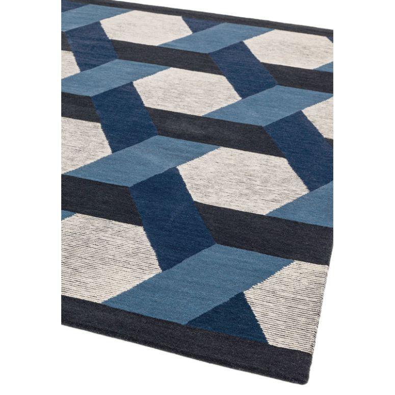 Geometric pattern rug in blue, navy and cream tones with textured surface, angled view