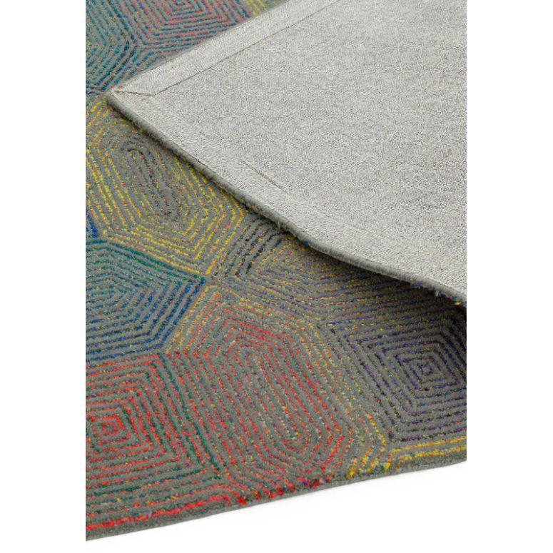 Multicolour geometric patterned rug corner with visible grey backing