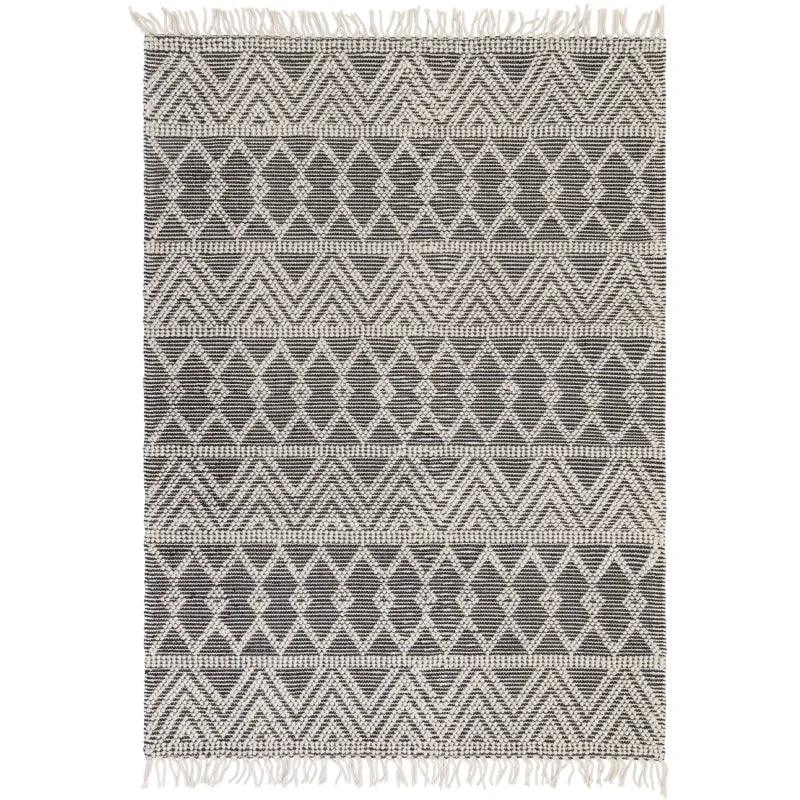 Black and cream geometric patterned rug with fringe edges, flat lay view