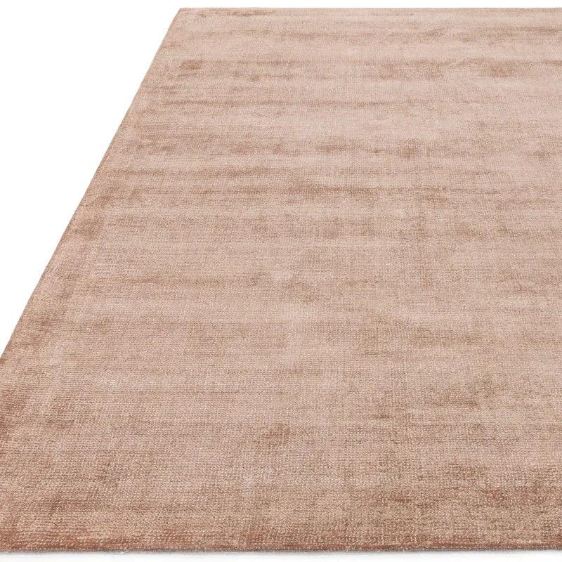 Beige area rug with soft textured pile and subtle sheen, shown from angled view