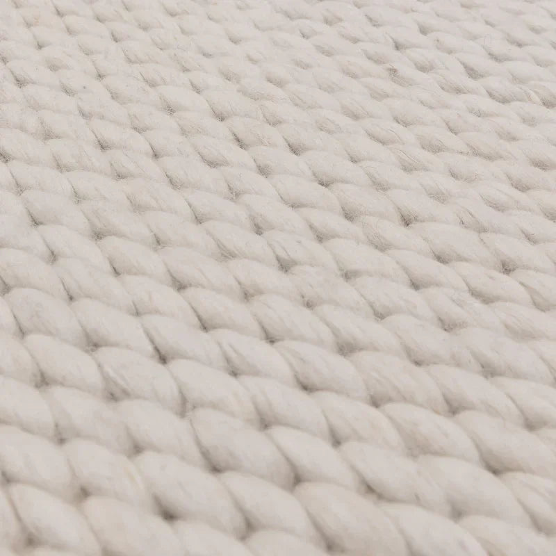 Closeup of chunky knit cream wool rug texture and weave pattern