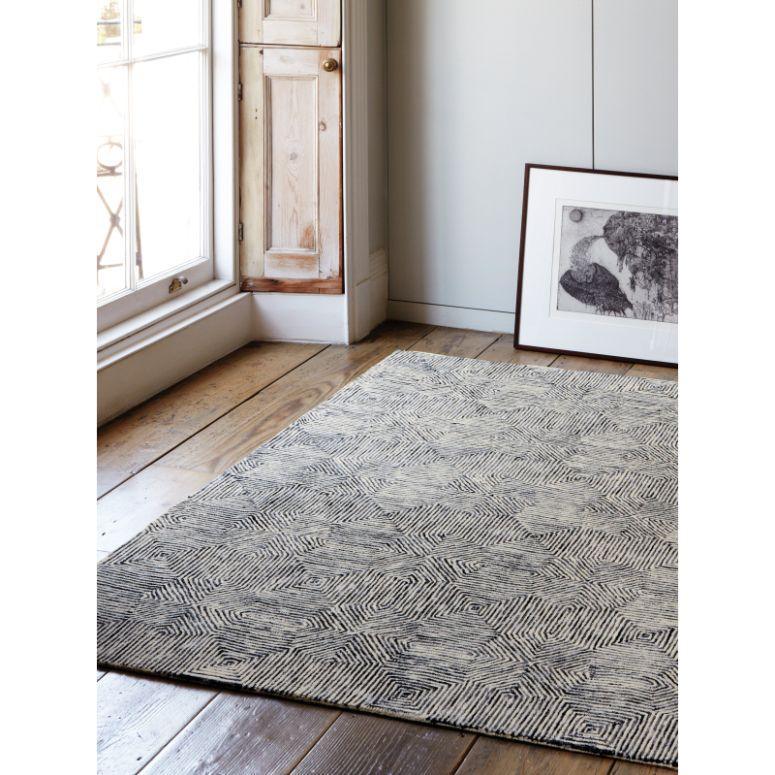 Modern patterned area rug on wooden floor in bright living room corner