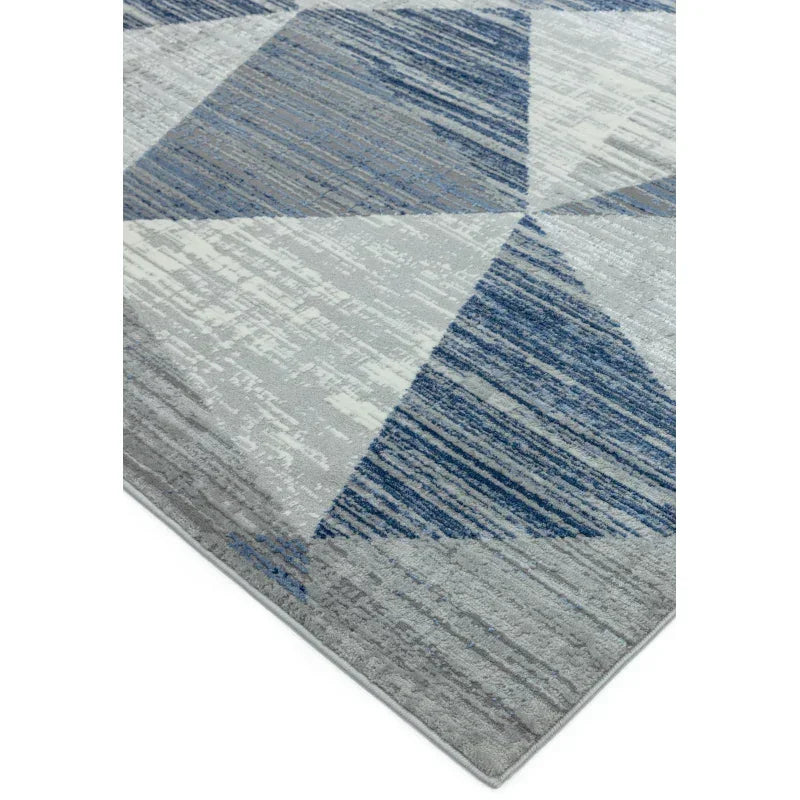Blue and grey geometric area rug with modern pattern, close-up of corner and texture