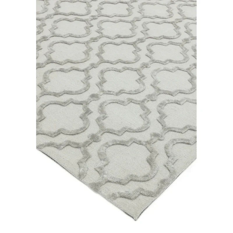 Beige patterned rug with raised geometric design and textured surface corner view